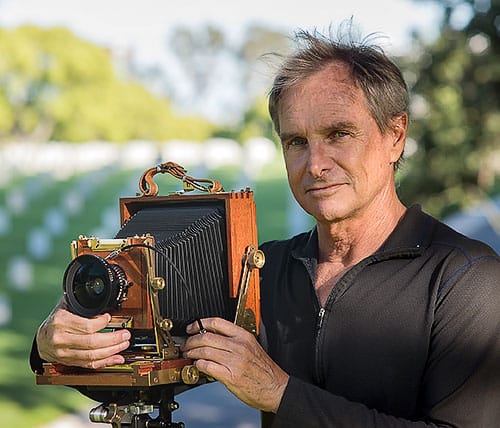 Director Jeff Crum with an antique camera at a Veterans Cemetery